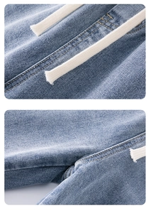 Dettaglio di jeans denim lavati blu con vita con coulisse bianca e cuciture gialle