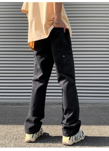 Detail view of black vintage carpenter pants with side pockets and metal rivets