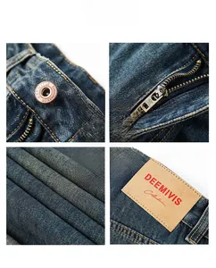 Detail view of washed blue denim fabric with metal button and leather brand patch