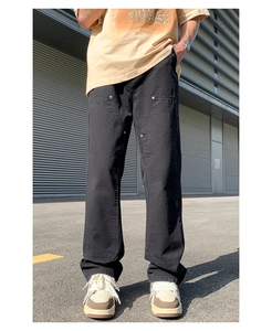 Detail of black double knee workwear pants with metallic rivets and heavy denim texture