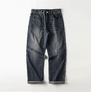 Detailed view of vintage washed dark blue straight jeans with metal button and cuffed hems