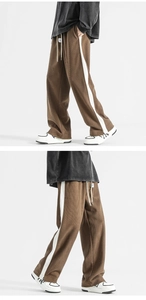Detailed side view of vintage wide-leg sweatpants with side stripes and split hem design