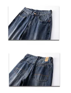 Detail view of vintage dark blue wide leg jeans with brown leather label and metal button