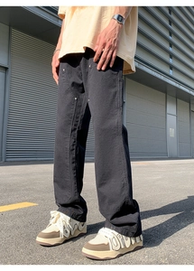 Detail of black double knee work pants with heavy canvas texture and metal rivets