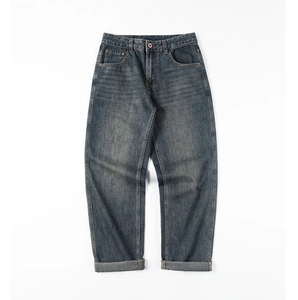 Detail view of vintage washed blue denim fabric with reinforced rivets and stitching