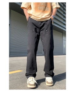 Detail view of black double-knee carpenter pants with metal rivets and relaxed straight fit