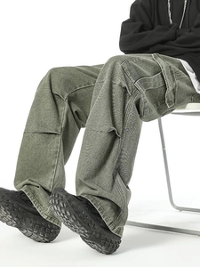 Men's olive green cargo pants with a wide leg fit and side pockets in a seated pose