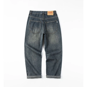 Rear view of vintage washed straight denim pants with back pockets and leather waist patch