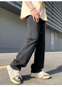 Detail shot of black cotton carpenter pants with functional side tool pockets and stitching