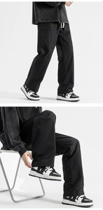Detail view of black wide-leg trousers featuring adjustable white drawstring waist and loose fit