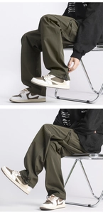 Detail view of military green cargo pants featuring drawstring cuffs and side zipper pockets