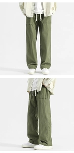 Detail of army green cargo pants featuring drawstring waist and large square pockets