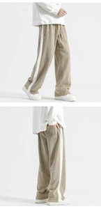 Detail view of khaki corduroy trousers with side stripes and adjustable drawstring waist