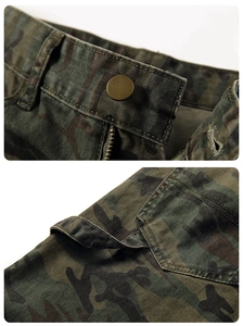 Detailed macro view of camo cargo pants featuring a bronze button and metal zipper closure