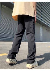 Detail of loose fit black cargo pants featuring heavy cotton fabric and reinforced pockets