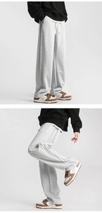 Detail of light gray wide-leg joggers featuring side stripes and a white drawstring waist