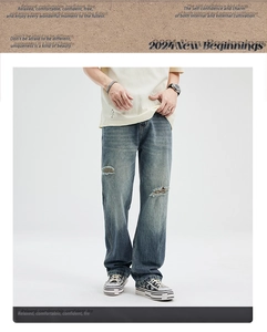 Detail of distressed hem on off-white t-shirt paired with vintage blue ripped jeans