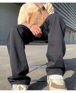 Detail of black double-knee carpenter pants showing heavy canvas fabric and stitching