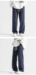 Detail of navy blue wide-leg trousers with white drawstring waist and large front pockets