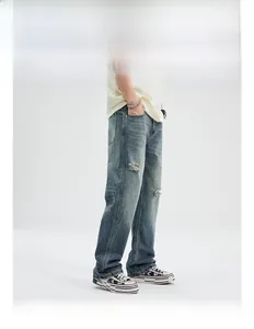 Detailed view of light blue washed denim jeans with knee distressing and flared hem