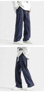 Detail view of dark blue wide-leg trousers showing elastic drawstring waist and fabric texture