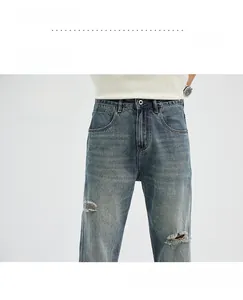 Close-up of vintage wash flared jeans featuring distressed knee rips and gradient texture