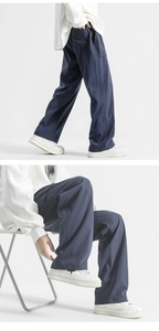 Detail view of navy blue wide-leg trousers showing relaxed fit and smooth fabric drape