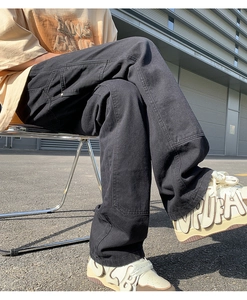 Detail view of black vintage cargo pants showing side pockets and reinforced stitching design