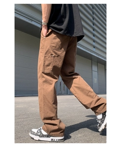 Side view of men's brown cotton carpenter pants with side pockets and loose fit