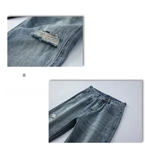 Detail view of light blue washed denim jeans featuring distressed ripped holes and stitching