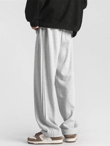 Relaxed fit gray track pants with side stripes and draped straight leg for unisex casual wear