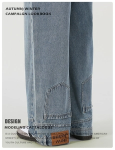 Detailed macro view of light blue denim cuff featuring orange leather brand patch and stitching