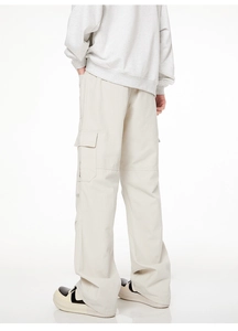 Vue détaillée d'un pantalon cargo crème avec de grandes poches latérales à rabat
