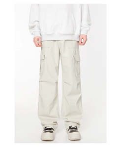 Détail d'un pantalon cargo beige pour homme avec coupe droite et grandes poches latérales