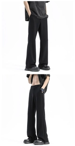 Detail showing the smooth drape and matte texture of men's black wide-leg trousers