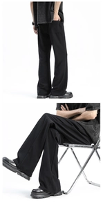 Close-up of men's black wide-leg trousers showing drape fabric and relaxed fit cut