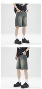 Detail of washed blue denim shorts featuring vintage whiskers and a relaxed retro fit