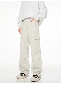 Détail du pantalon cargo blanc cassé avec grandes poches à rabat et texture sergé de coton