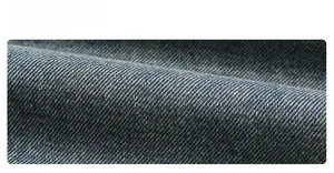 Détail macro du tissu denim délavé bleu haute densité avec texture sergée et doublure