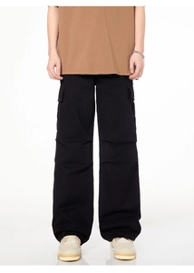 Détail du pantalon cargo noir à jambes larges avec grandes poches et plis aux genoux