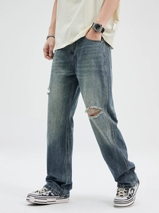 Men's light blue flared jeans with vintage gradient wash, ripped knees and side stitching