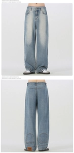 Close-up of vintage light blue wide-leg jeans featuring whiskers and a branded hem tag