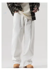 Détail du pantalon blanc à jambe droite en coton épais avec un tombé fluide élégant