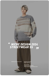 Close-up of minimalist brown wide-leg trousers paired with a striped knit sweater