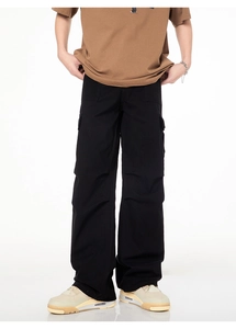 Détail du pantalon cargo large noir pour homme avec poches à rabat et plis aux genoux