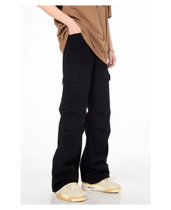 Détail du pantalon cargo noir ample avec de grandes poches latérales et style streetwear
