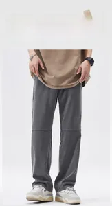 Detail of loose straight-leg dark gray fleece-lined casual pants with knee stitching