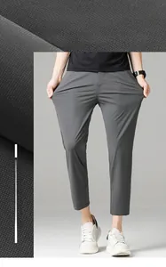 Close-up of dark grey ice silk trousers fabric texture and slim fit straight leg design