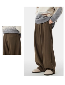Detail showing deep brown wide-leg trousers with soft drape and pleated side pockets