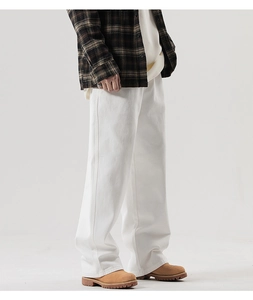 Détail du pantalon large en coton blanc avec coupe droite et surpiqûres de haute qualité